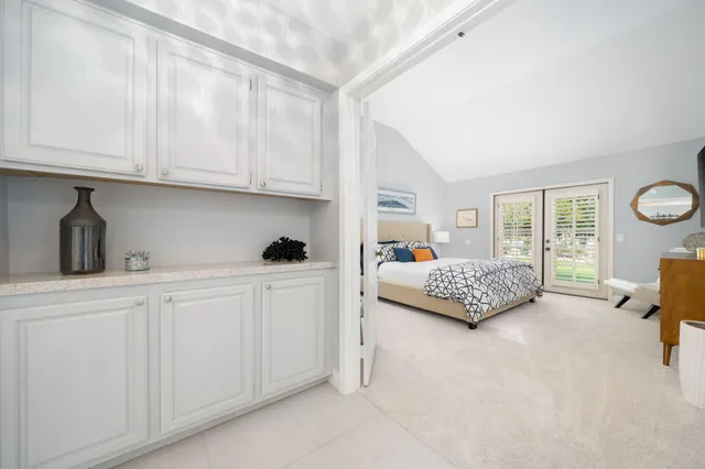 a bedroom with furniture and a large window