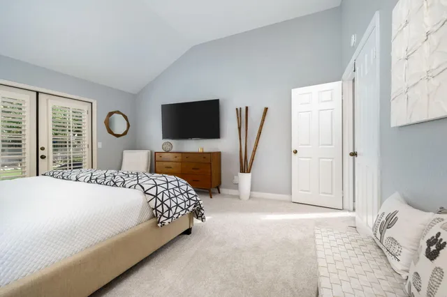a bedroom with a bed and a flat tv screen on dresser