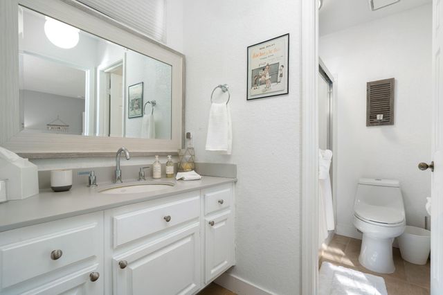 a bathroom with a granite countertop toilet sink and a mirror