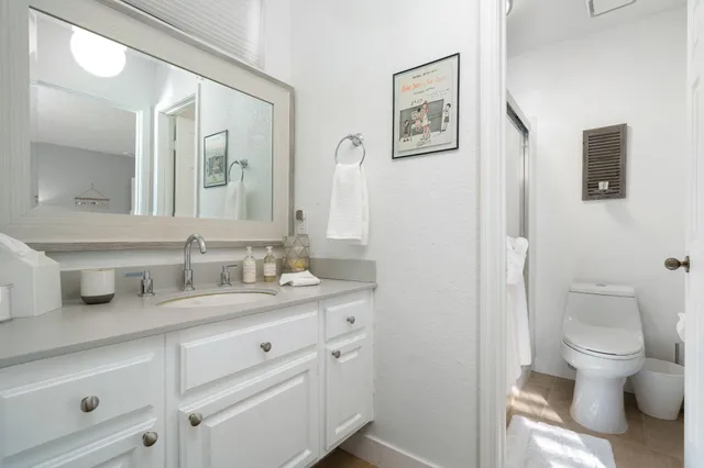 a bathroom with a granite countertop toilet sink and a mirror