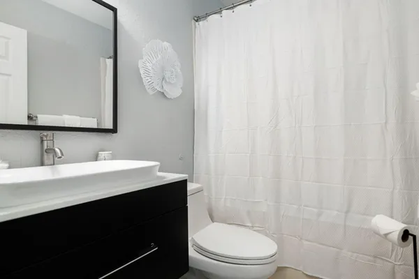 a bathroom with a sink a toilet and shower