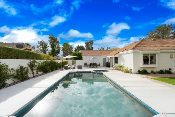 a view of a house with swimming pool and sitting area