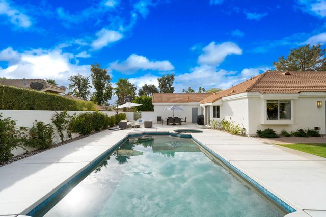 a view of a house with swimming pool and sitting area