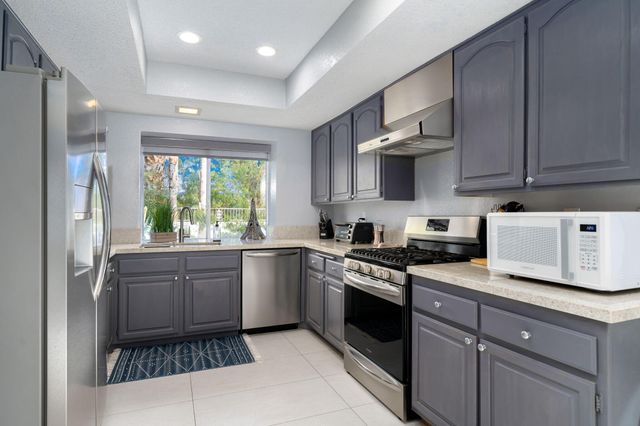 a kitchen with stainless steel appliances granite countertop a stove sink and cabinets