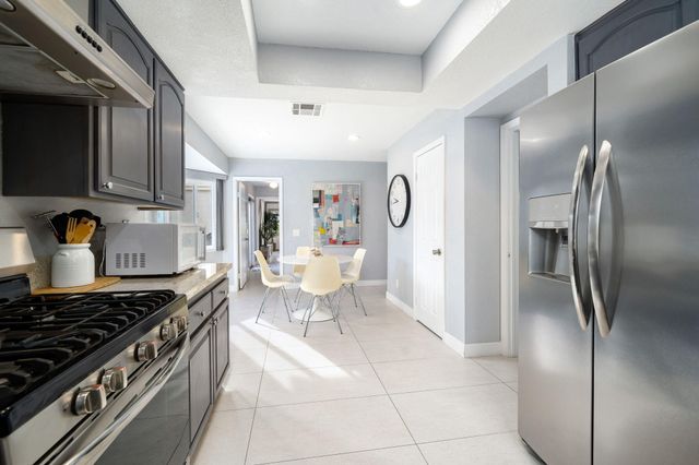 a kitchen with stainless steel appliances granite countertop a stove a refrigerator and a sink