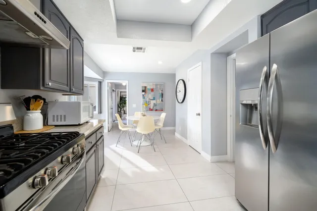 a kitchen with stainless steel appliances granite countertop a stove a refrigerator and a sink