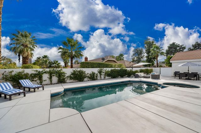 a view of a patio with couches and a table and chairs with potted plants