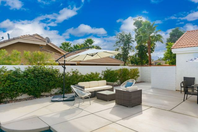 a view of a patio with table and chairs under an umbrella