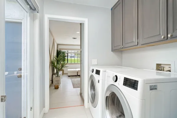 a view of washer and dryer with kitchen in the background