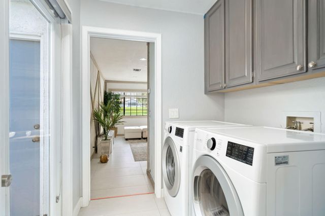 a view of washer and dryer with kitchen in the background