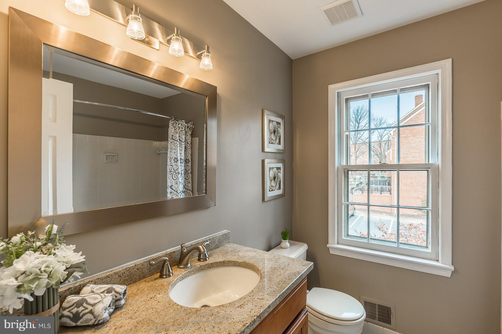 1237 Portner Road Alexandria, VA 22314 - Photo 13 of 17 a bathroom with a granite countertop sink toilet and mirror