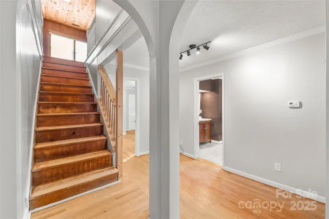 a view of a hallway with wooden floor and windows