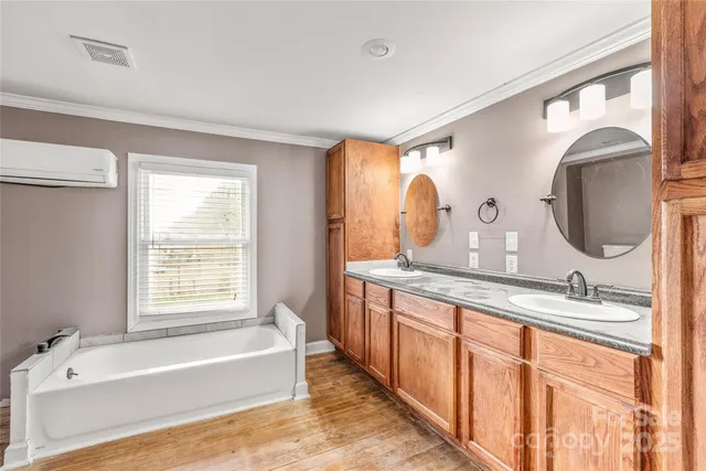 a bathroom with a granite countertop sink mirror and bathtub