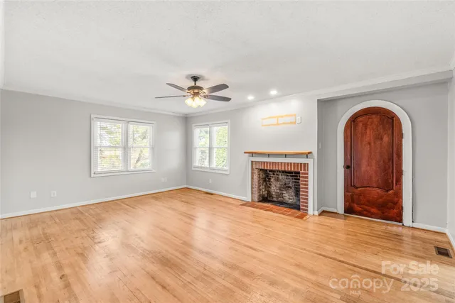 a view of empty room with fireplace and windows