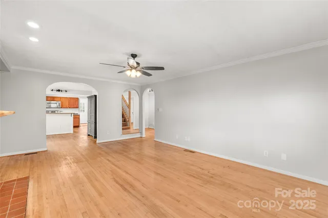 a view of an empty room with a chandelier fan