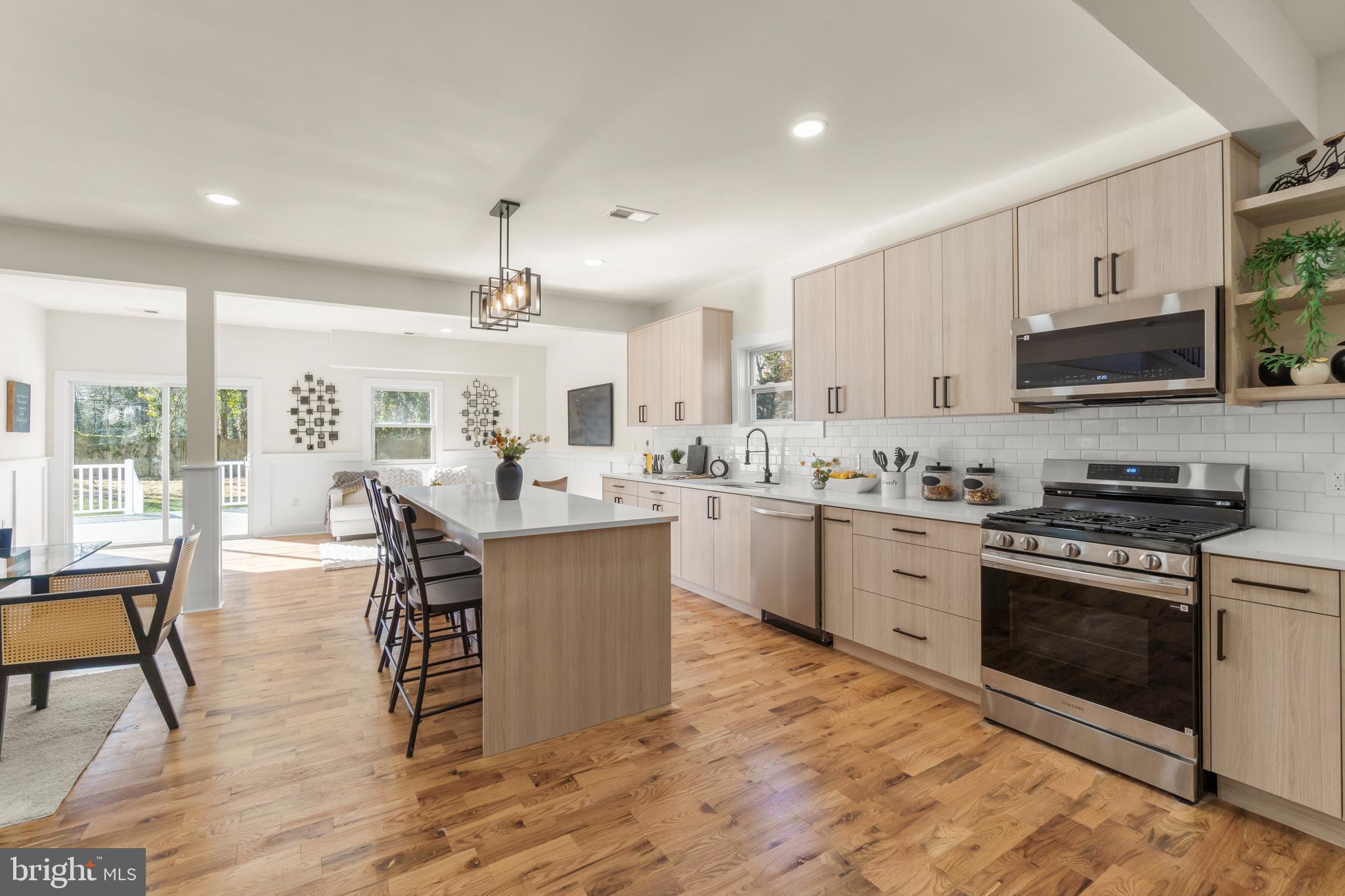 32 Wagon Bridge Run Moorestown, NJ 08057 - Photo 8 of 41 a kitchen with stainless steel appliances granite countertop a stove top oven a sink dishwasher a dining table and chairs with wooden floor