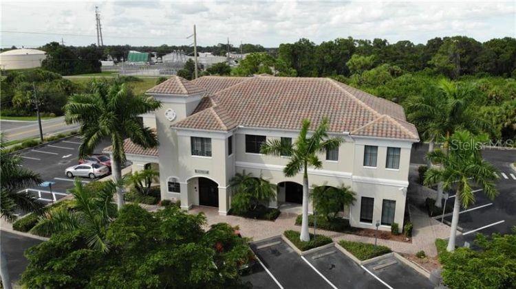 5900 Pan American Boulevard, Unit 205 North Port, FL 34287 - Photo 8 of 8 a aerial view of a white house with a yard table and chairs