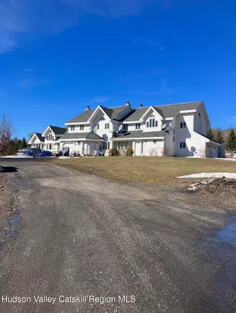a view of a large house with a big yard and large trees