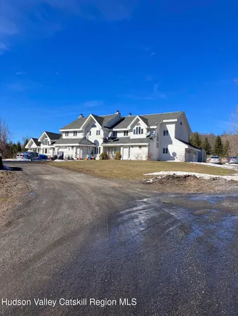 a view of a large house with a big yard and large trees