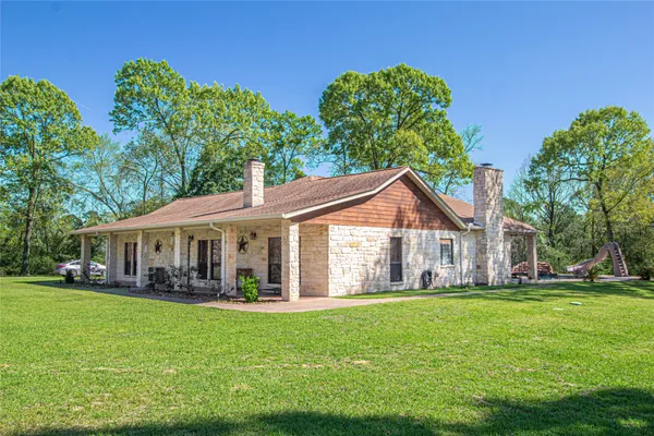 a front view of a house with a garden and trees