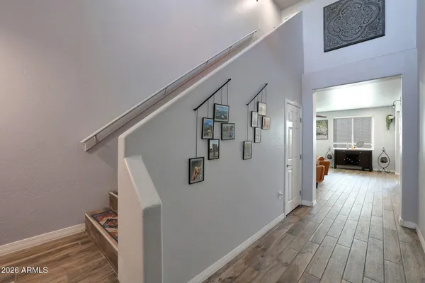 a view of a hallway with wooden floor and staircase