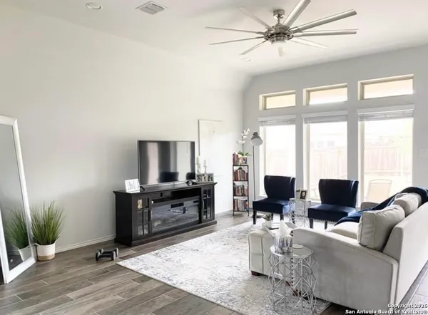 a living room with furniture a large window with wooden floor