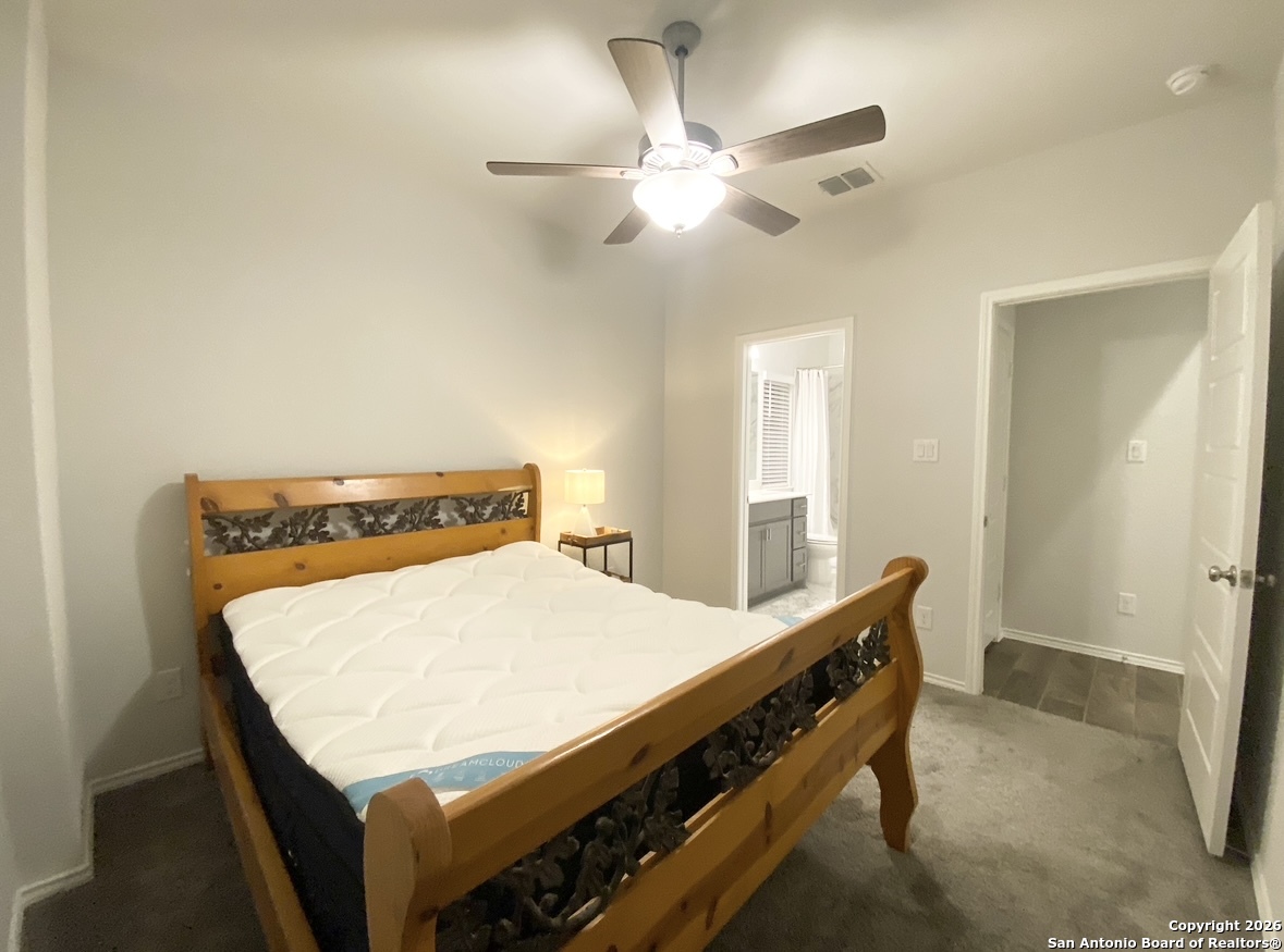 9358 Boiling Rapid San Antonio, TX 78254 - Photo 11 of 22 a bedroom with a bed and a chandelier