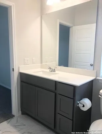 a bathroom with a sink vanity and a mirror