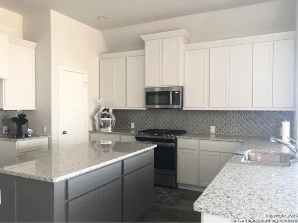 a kitchen with stainless steel appliances granite countertop a sink stove and cabinets
