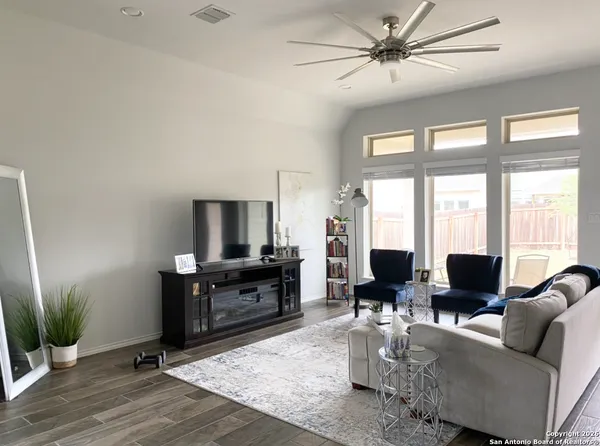 a living room with furniture a large window with wooden floor