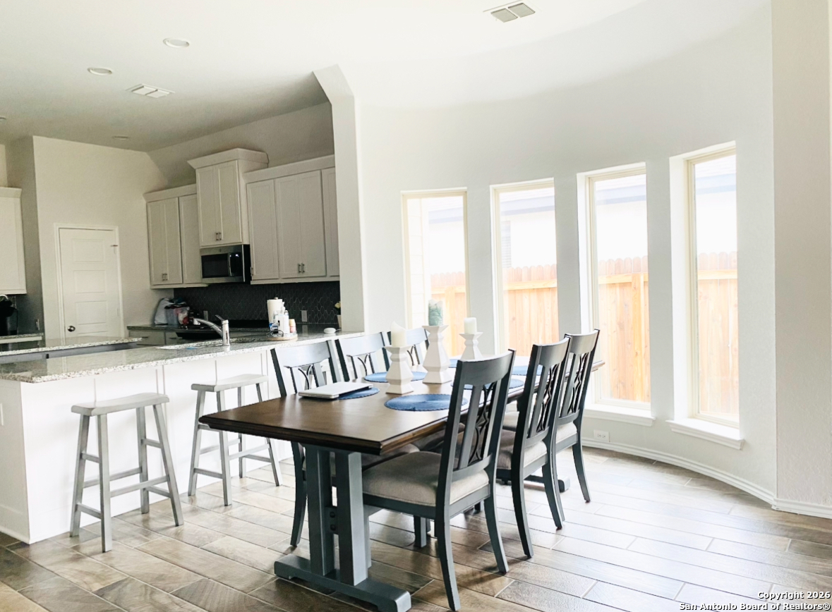 9358 Boiling Rapid San Antonio, TX 78254 - Photo 5 of 22 a view of a dining room with furniture and wooden floor