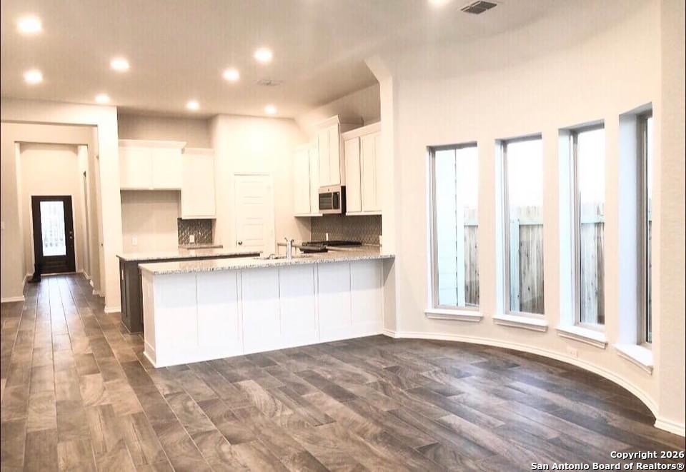 9358 Boiling Rapid San Antonio, TX 78254 - Photo 6 of 22 a view of a kitchen with kitchen island granite countertop a refrigerator sink and white cabinets