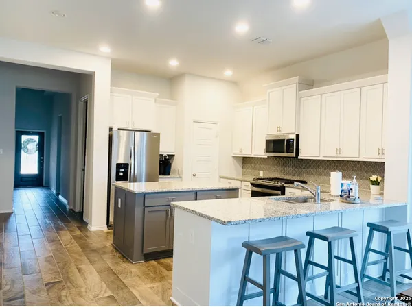 a kitchen that has a lot of cabinets in it and appliances