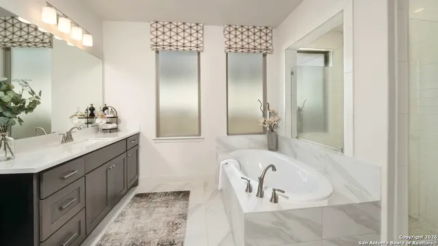 a bathroom with double vanity sinks and a bathtub
