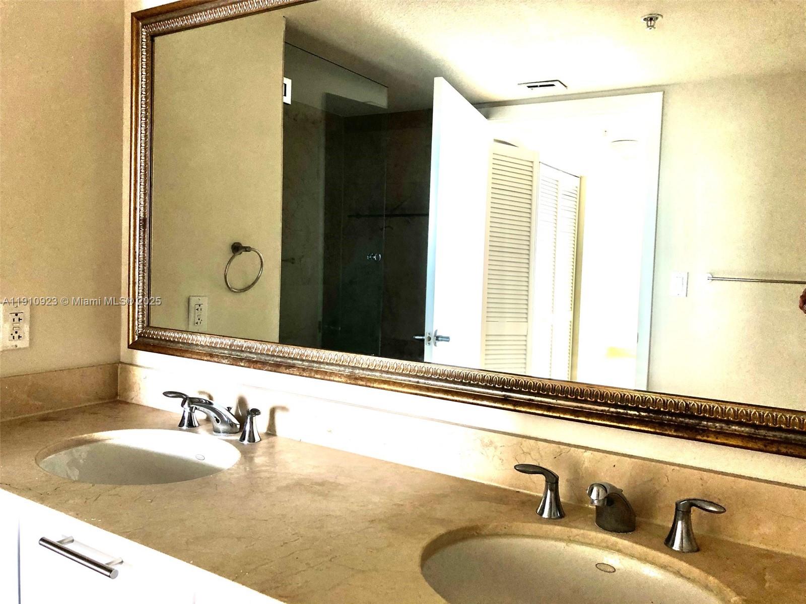 1800 North Bayshore Drive, Unit 605 Miami, FL 33132 - Photo 9 of 48 a bathroom with a granite countertop sink and a mirror