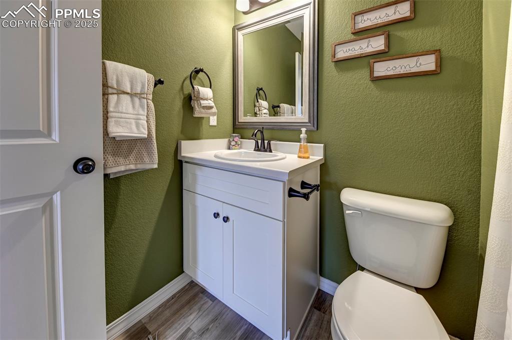 7311 Cornice Point Colorado Springs, CO 80923 - Photo 15 of 32 a bathroom with a toilet a sink and mirror