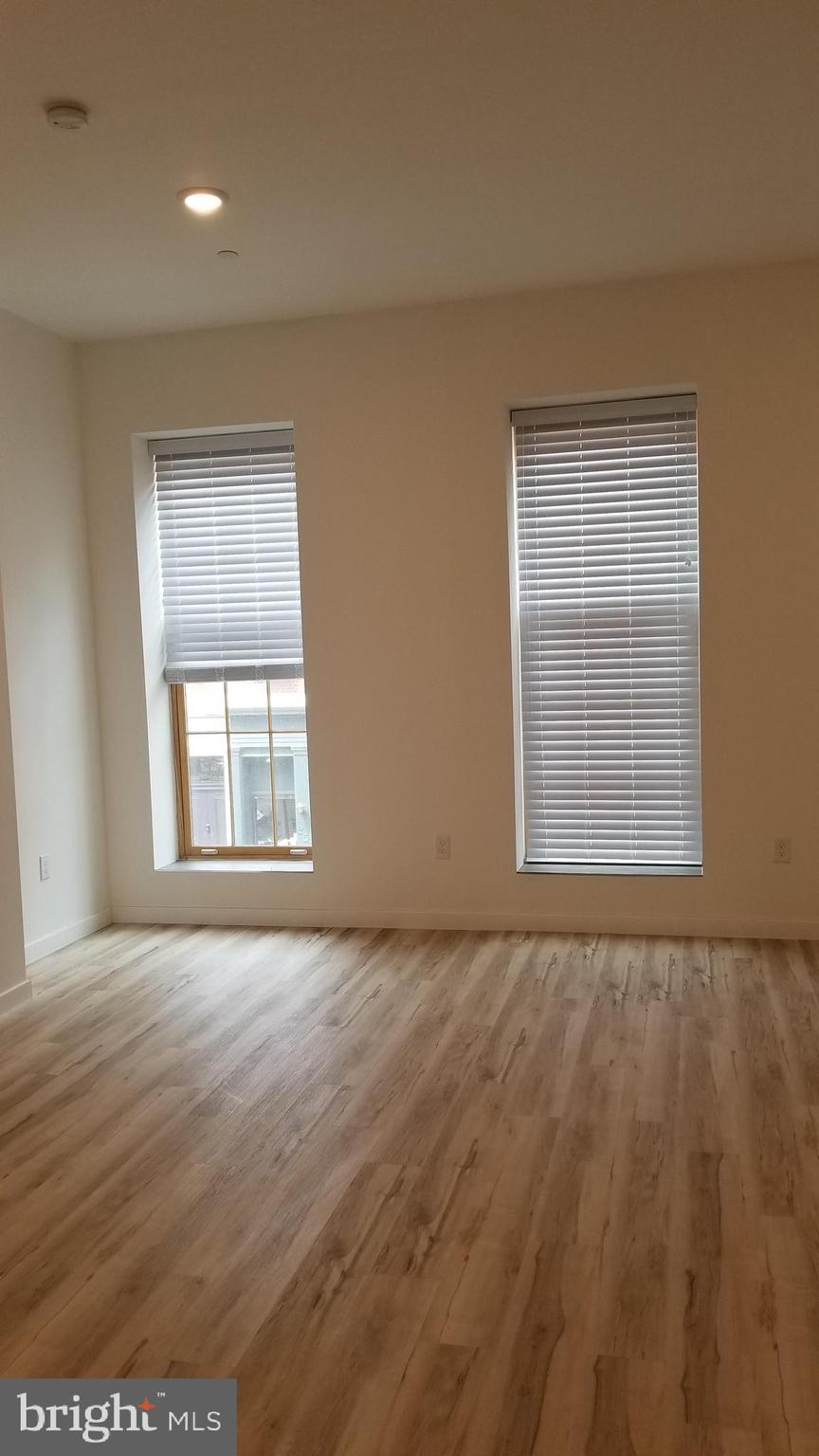 247 South 16th Street, Unit 5 Philadelphia, PA 19102 - Photo 3 of 10 an empty room with wooden floor and windows