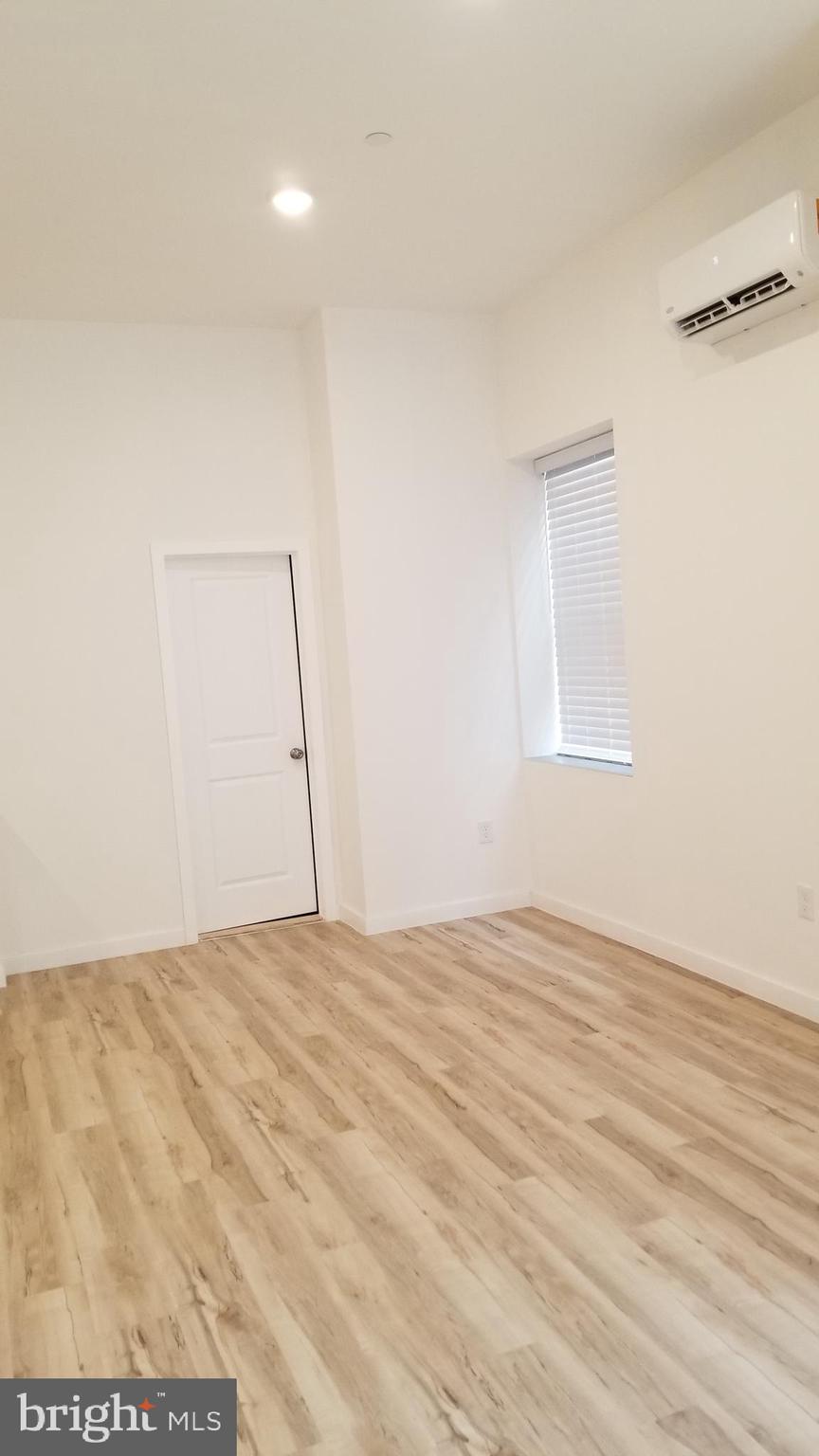 247 South 16th Street, Unit 5 Philadelphia, PA 19102 - Photo 4 of 10 a view of an empty room with wooden floor and a window