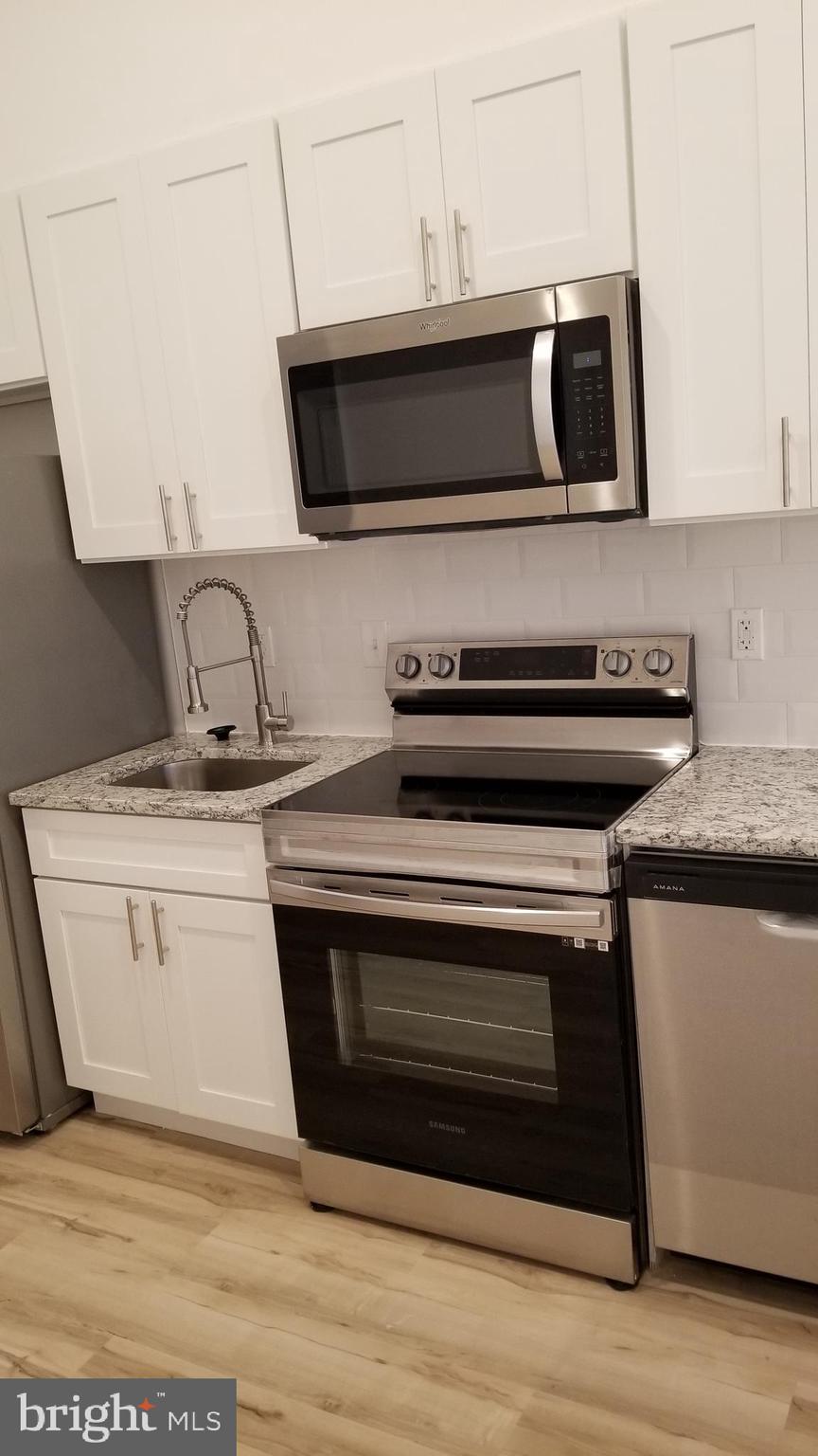 247 South 16th Street, Unit 5 Philadelphia, PA 19102 - Photo 6 of 10 a kitchen with stainless steel appliances a stove microwave and sink