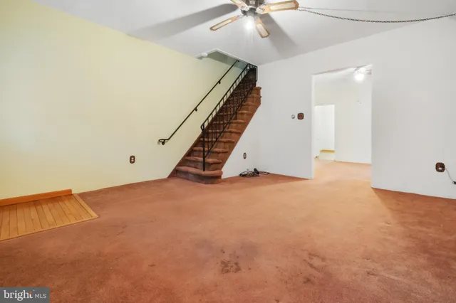 an empty room with staircase and white walls