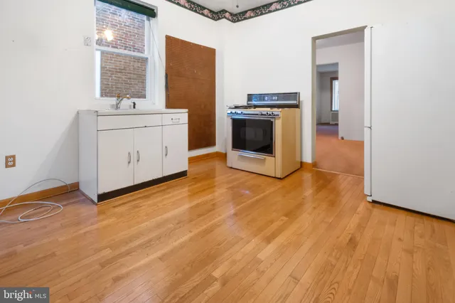 a view of empty room with wooden floor and cabinet