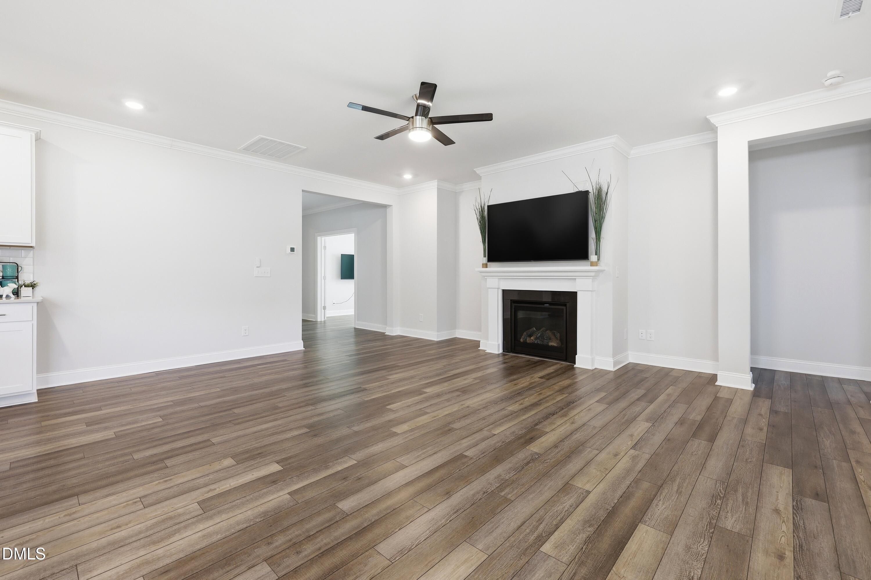 289 English Violet Lane Raleigh, NC 27610 - Photo 17 of 40 a view of a livingroom with a fireplace a ceiling fan and wooden floor