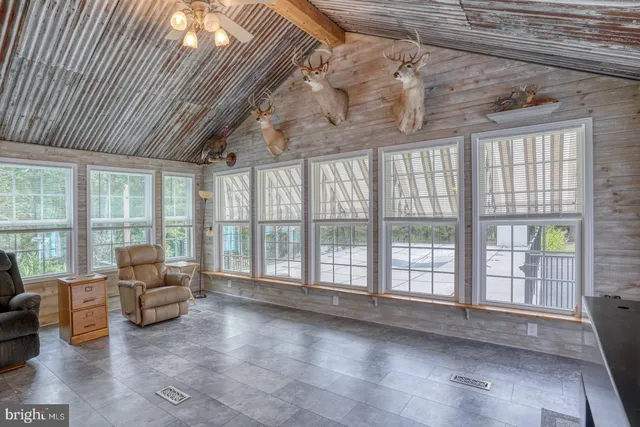 a kitchen with stainless steel appliances granite countertop a refrigerator a stove a sink a dining table and chairs with wooden floor