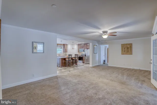 a dining hall with stainless steel appliances granite countertop a kitchen island a stove and a wooden floors