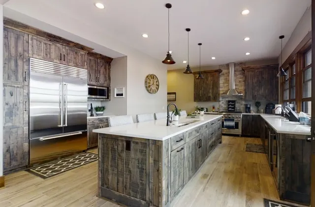 a kitchen with stainless steel appliances kitchen island granite countertop a sink a stove and cabinets