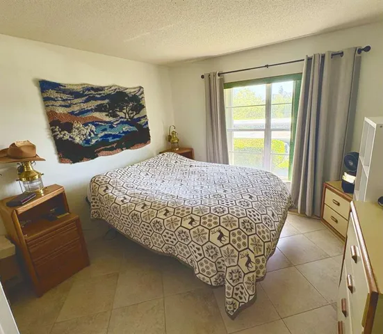 a room with a bed and a painting on the wall