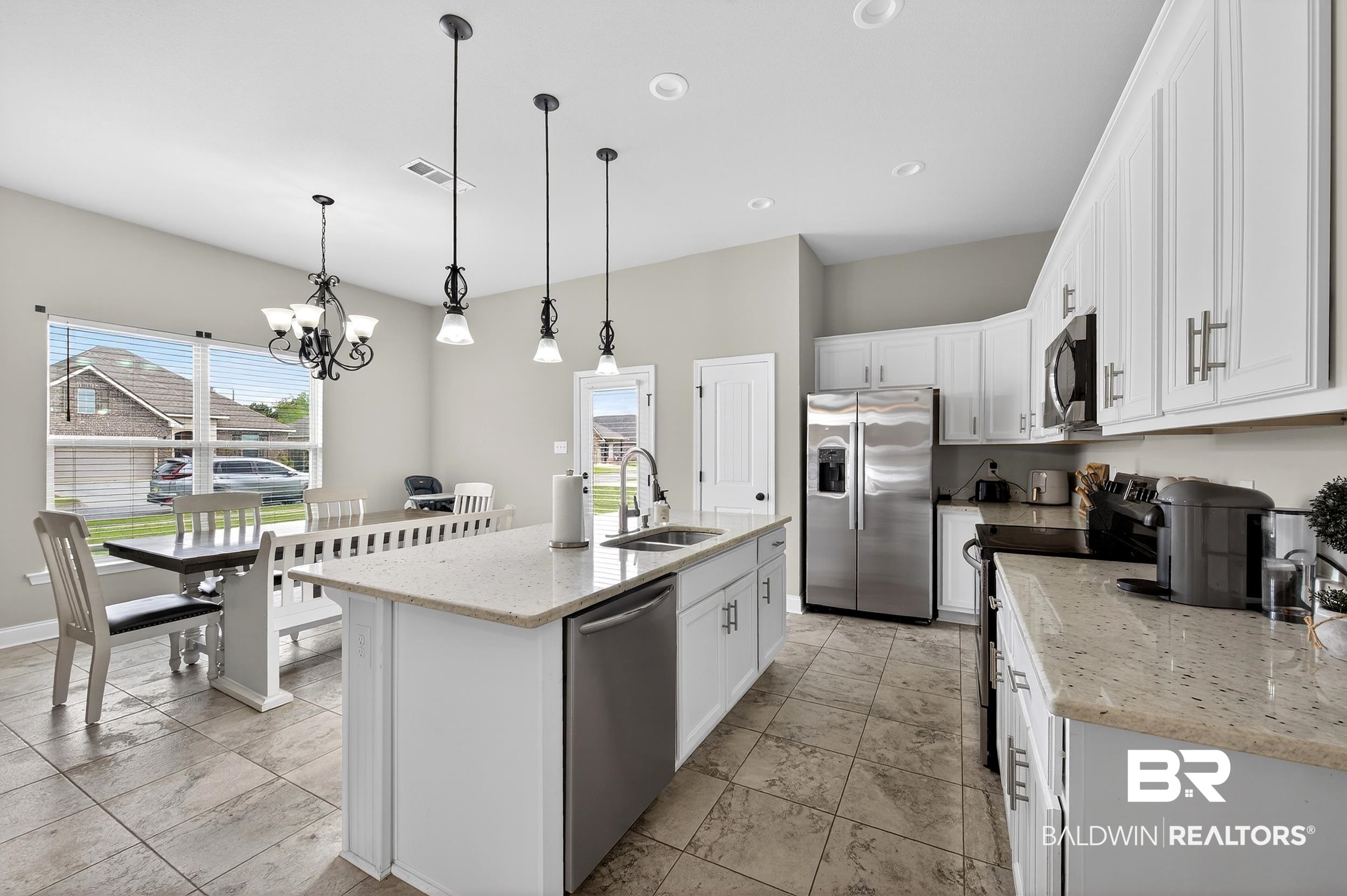 1084 Stella Road Foley, AL 36535 - Photo 14 of 31 Kitchen featuring light stone counters, white cabinets, stainless steel appliances, a kitchen island with sink, and plenty of natural light