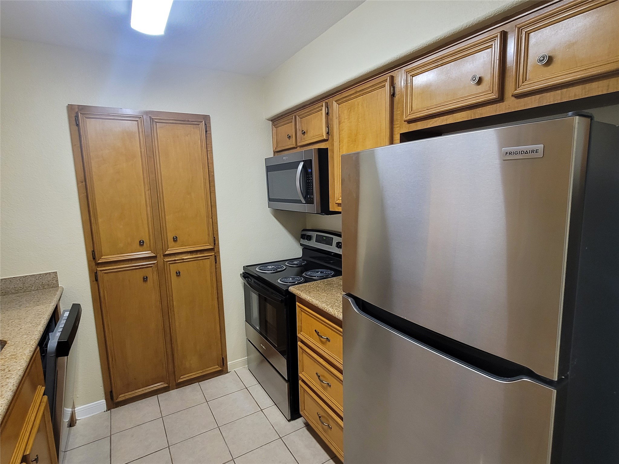 215 Postoffice Street, Unit 801 Galveston, TX 77550 - Photo 6 of 16 a kitchen with stainless steel appliances granite countertop a refrigerator and a stove