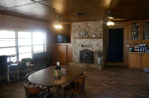 a dining room with furniture a fireplace and wooden floor