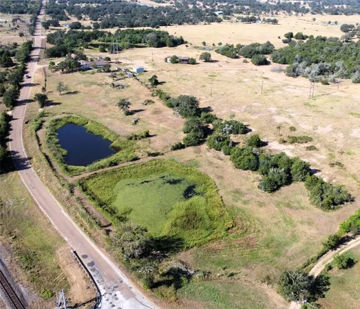 an aerial view of a house with a yard and lake